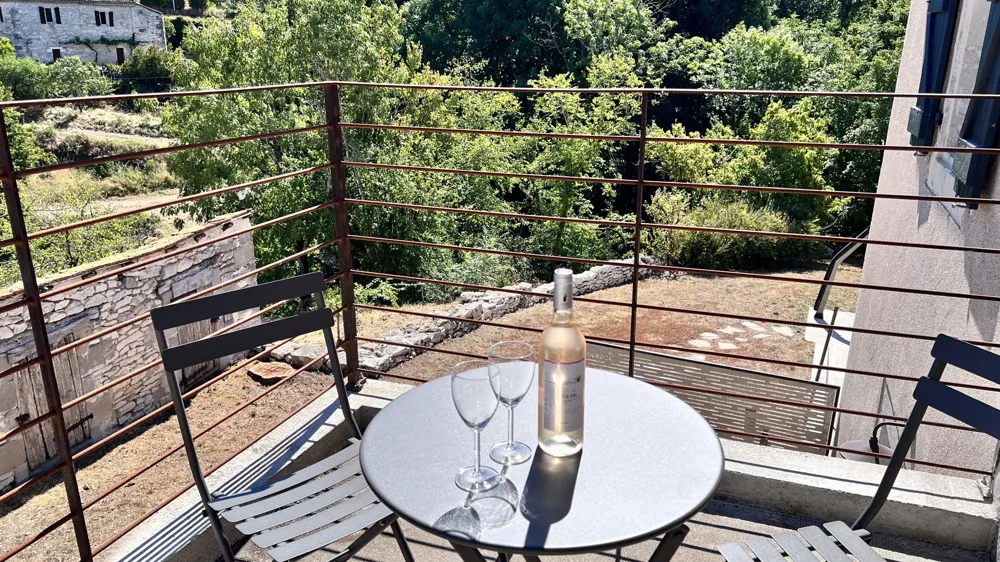Balcony with round table, glasses and bottle