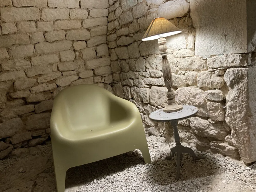 Armchair and lamp in a corner of the stone cellar