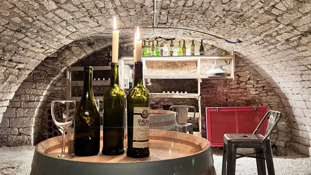 Wine bottles on a barrel in the vaulted cellar