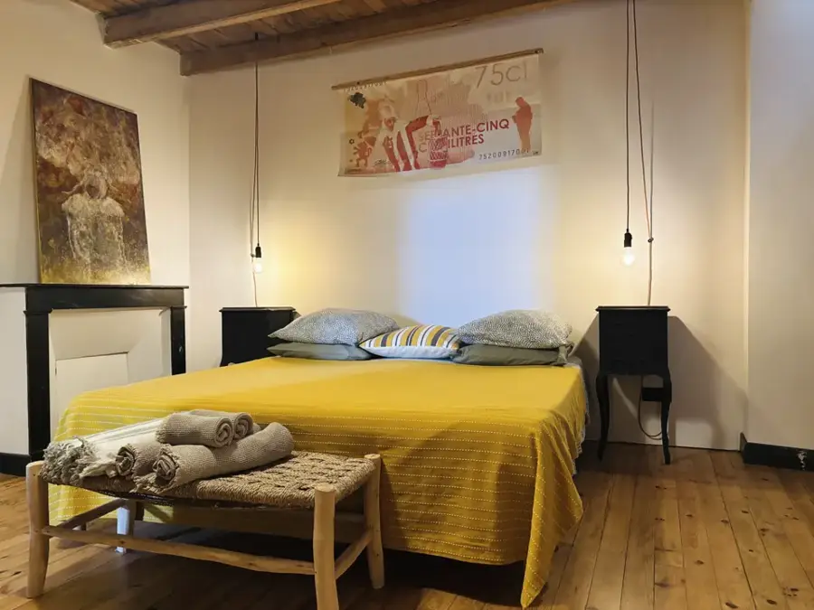 Binche bedroom with yellow bedspread and old parquet