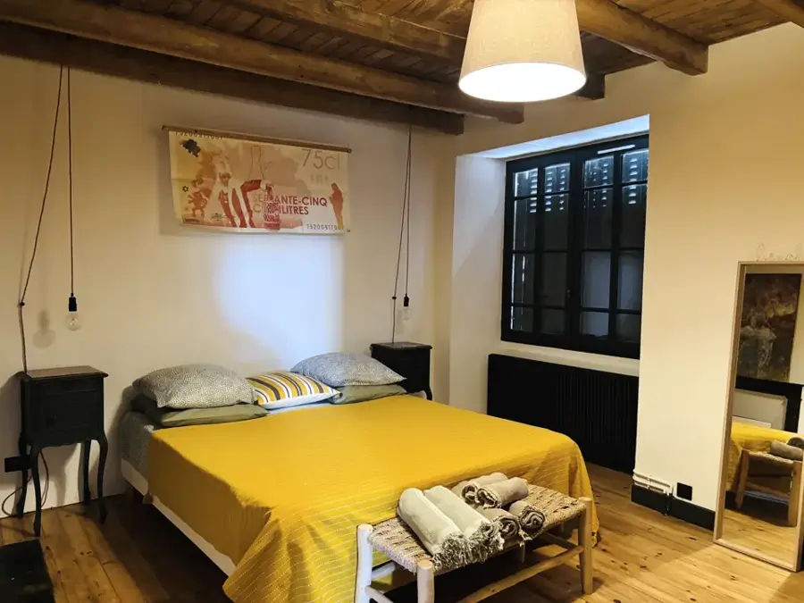 Binche bedroom with yellow bed and shuttered window