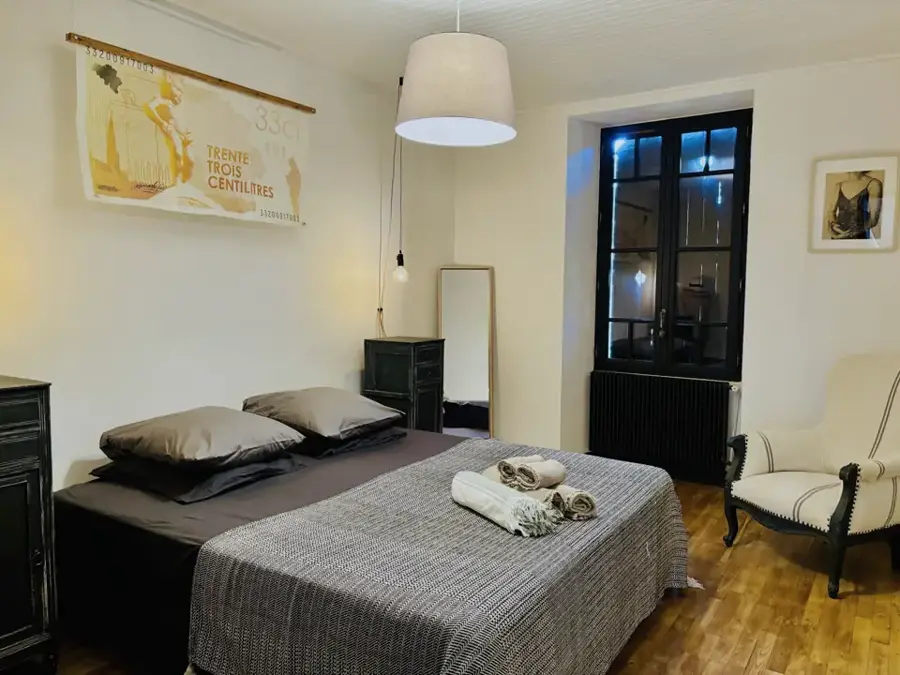 Bruxsel bedroom with double bed, grey linen and vintage poster