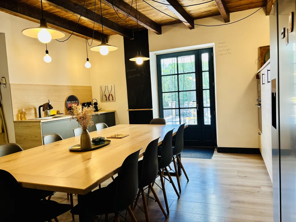 Equipped kitchen with a long wooden table and glass door