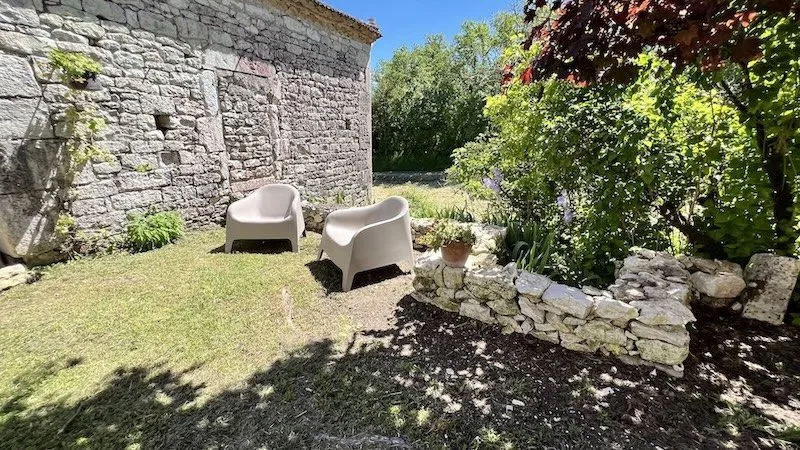 Garden chairs next to a stone wall