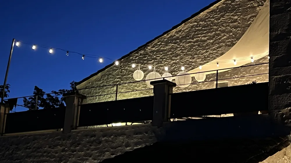 String lights on the stone wall in the evening