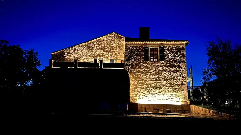 The stone house lit up at night