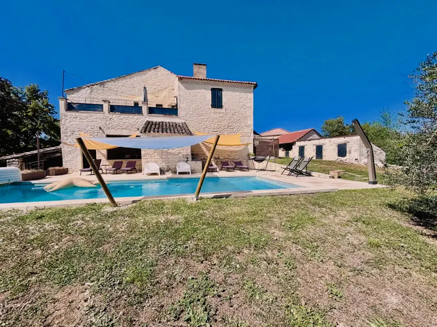 Pool seen from the garden, with the stone house