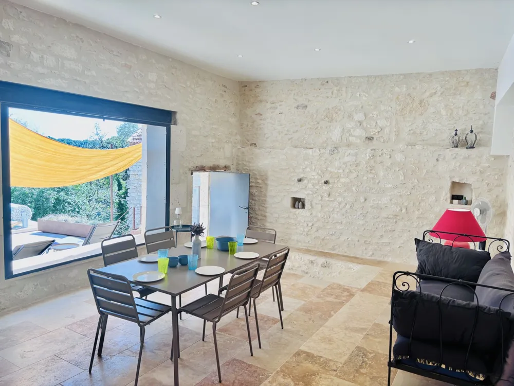 Summer room with large table and view of the pool
