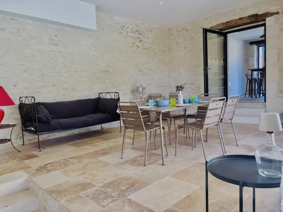 Stenen zomerzaal met tafel en zwarte zetel