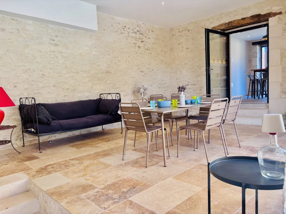 Stone summer room with large table and sofa