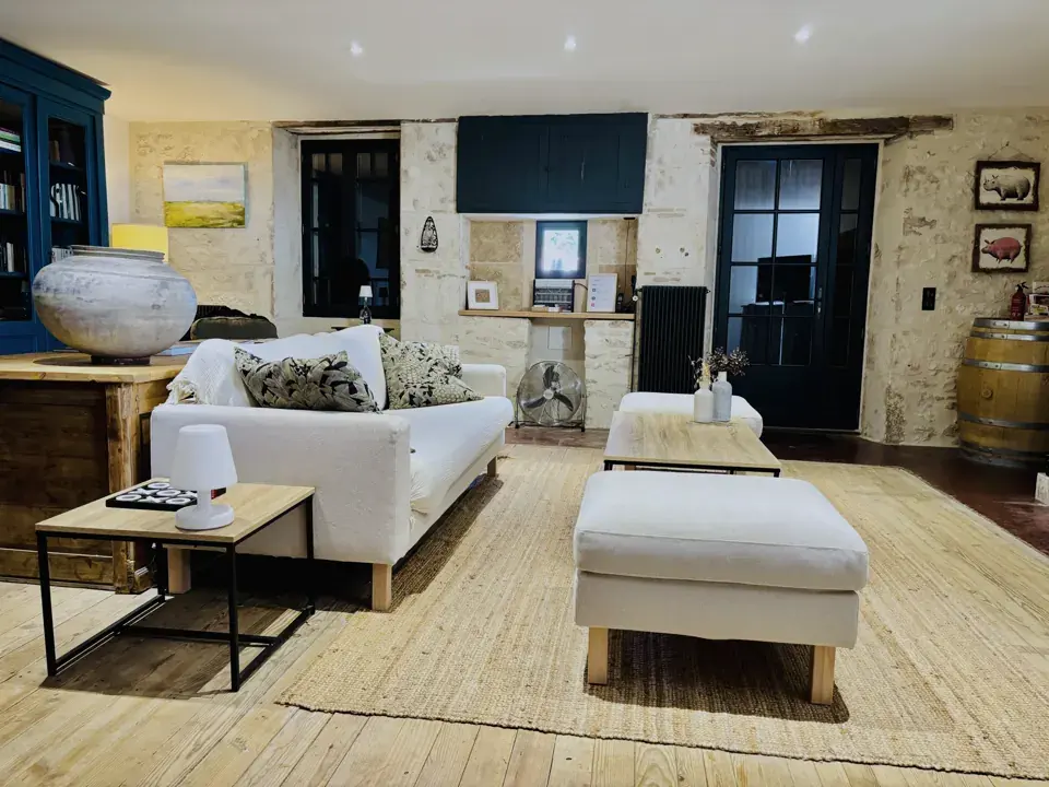 Woonkamer met witte zetel, poef en tapijt