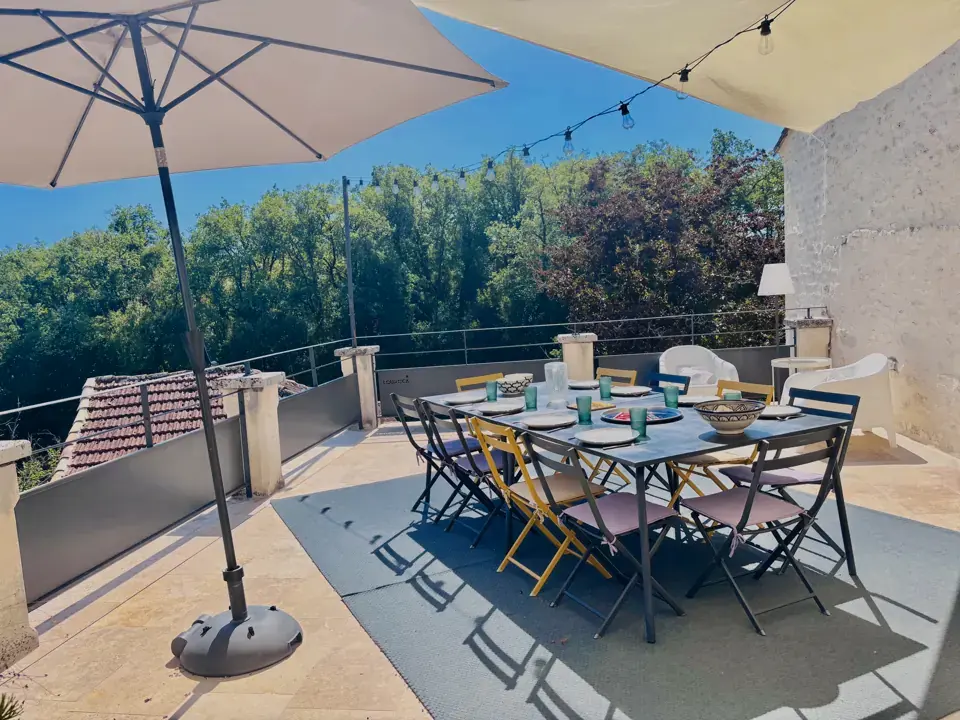 Hoog terras met grote tafel en parasol